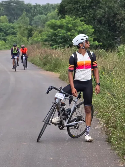 Another rider enjoying the view on a quiet, tree-lined road during the Rajyotsava 200k ride. It's not just about the distance, but also the journey.