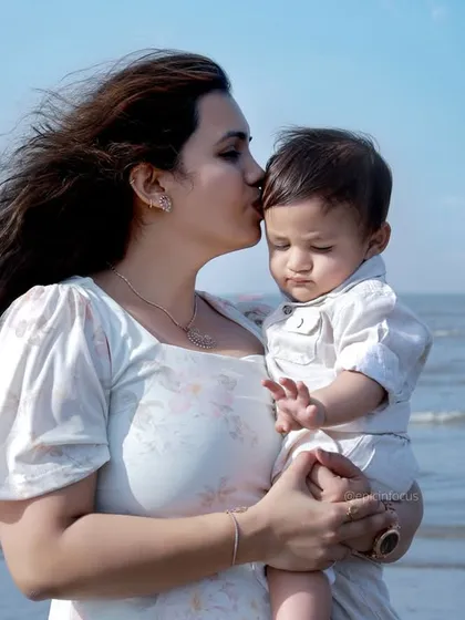 We take our studio magic to the beach for natural, sun-kissed family portraits. A mother's gentle kiss against the backdrop of the sea creates a serene and beautiful memory of your family's love.