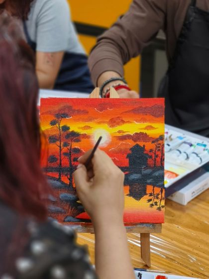 A close-up shot of a participant adding the final details to her painting. Our workshops focus on both learning techniques and enjoying the meditative process of creating art.