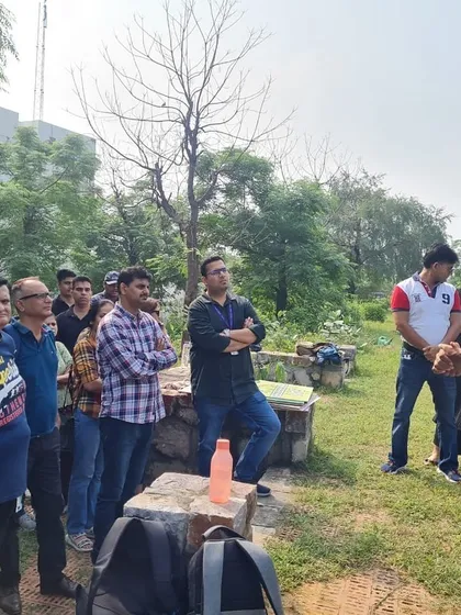 Rewilding expert Vijay Dhasmana educates a group of attentive volunteers from NatWest about the specific native species they are about to plant and their role in the ecosystem.