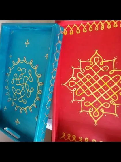 A beautiful pairing of a blue tray with a hand-painted Kolam design and a red tray with a more intricate Sikku Kolam. These traditional patterns bring a touch of South Indian heritage to functional homeware.