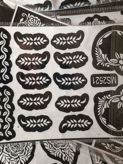 A stencil sheet with delicate vine and leaf patterns. These are perfect for creating borders or adding small details to your henna design.