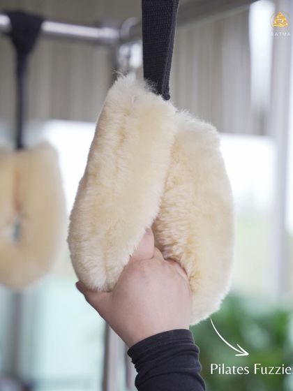 The 'fuzzies' or hanging straps on the Cadillac are used for a variety of exercises that challenge the upper body and core, including pull-ups and hanging stretches.