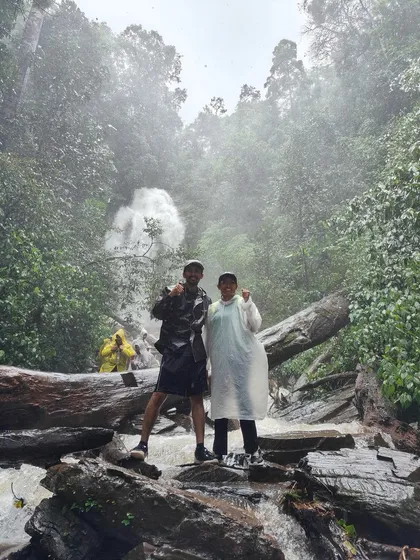 Two trekkers posing in front of Hidlumane Falls. The raw power of the waterfall is incredible up close.