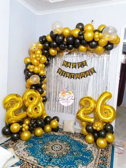A simple yet elegant black and gold balloon arch for a 28th or 26th birthday celebration at home.