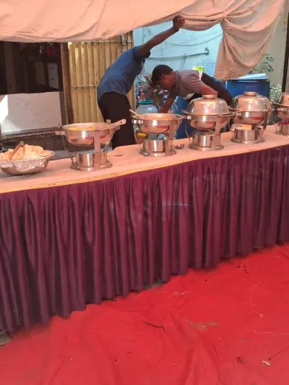 My team setting up the buffet table before an event. I handle everything from setting up the tables to arranging the food, so you don't have to worry.