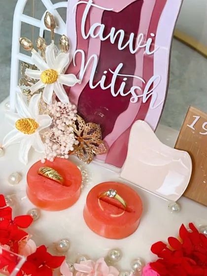 A close-up on the custom ring holders and the wooden date plaque. Every element is designed to match the couple's theme.
