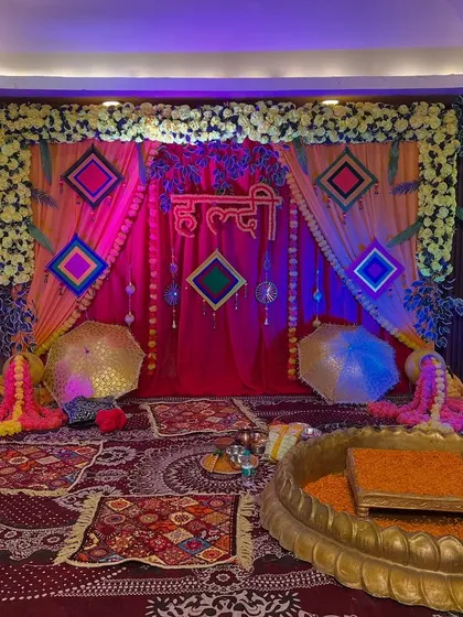 The Haldi stage illuminated with pink and blue lights, showing the versatility of the setup for different moods and photo opportunities.