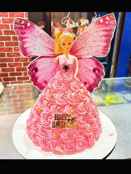 A classic Barbie doll cake with a beautiful pink rosette dress and butterfly wings.
