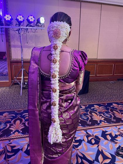 My signature style. This image perfectly captures the grandeur of a traditional South Indian floral braid, a skill I have honed over many years.