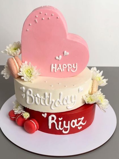 Another angle of the lovely heart-themed birthday cake, highlighting the fresh flowers and macarons.