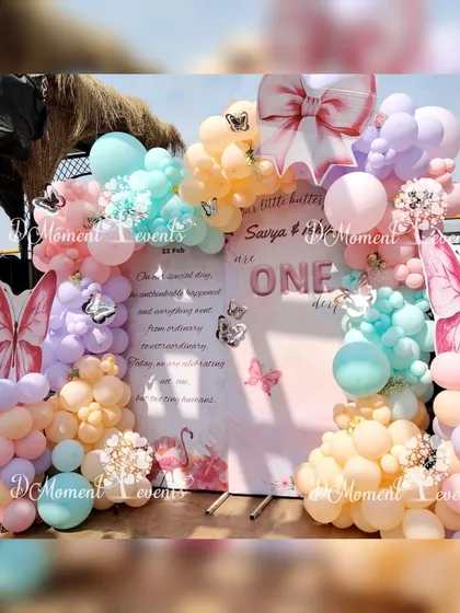Another angle of the twins' butterfly-themed photo backdrop, showing the beautiful combination of pastel balloons and elegant butterfly wing props.