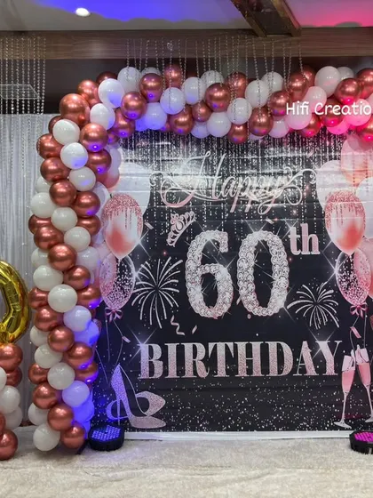 Milestone birthdays deserve a grand celebration. For this 60th birthday, we created an elegant and sophisticated look with a rose gold and white balloon arch, a personalized backdrop, and large foil number balloons to mark the special year.