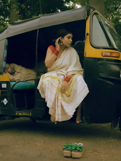 Capturing candid moments in unexpected places. This shot uses a Mumbai auto-rickshaw as a prop, adding a layer of authentic city life to this traditional saree portrait.