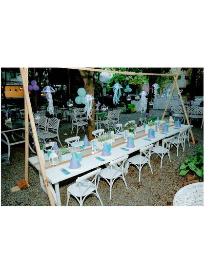 A wide shot of the mermaid-themed kids' table, showing the full setup in a beautiful outdoor setting.