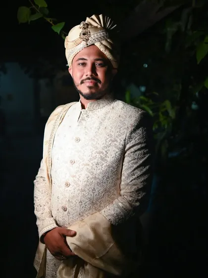 A handsome portrait of the groom, ready for his Nikkah ceremony. The soft, dark background makes his traditional attire stand out, capturing his quiet confidence.