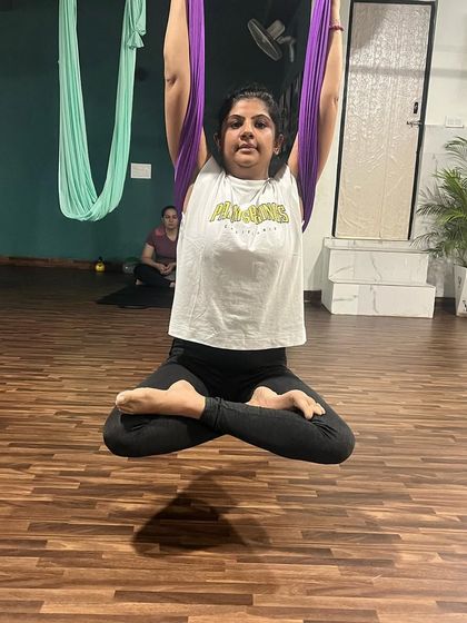 The floating lotus pose, or Padmasana, is a meditative posture that finds new life in the air. It challenges balance and core stability while promoting a sense of calm and centeredness.