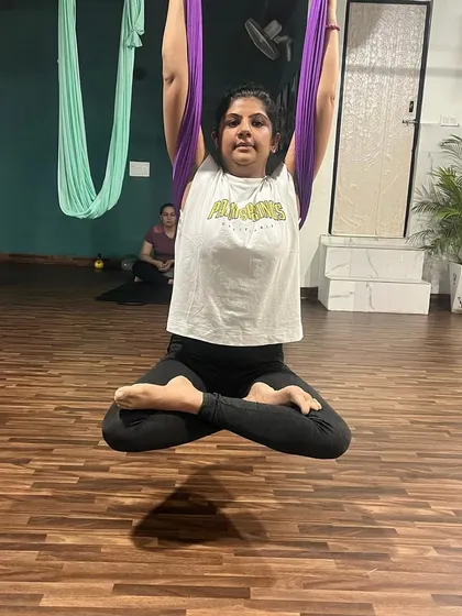 The floating lotus pose, or Padmasana, is a meditative posture that finds new life in the air. It challenges balance and core stability while promoting a sense of calm and centeredness.