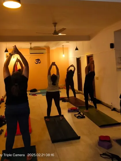 A class moving through the initial stages of Surya Namaskar. This foundational sequence warms up the entire body and is a core part of many of our Hatha and flow yoga classes.