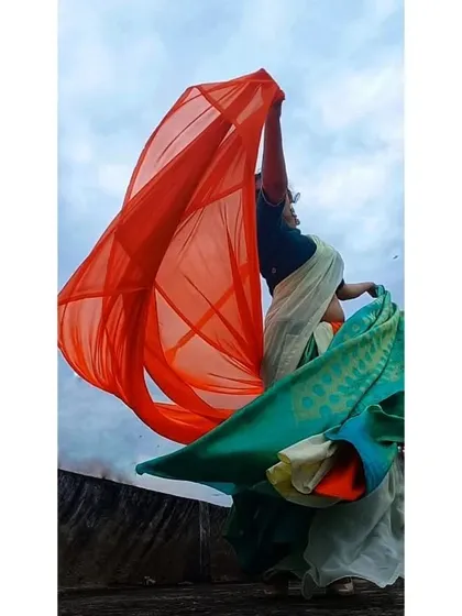 A dynamic shot from the tricolor-themed shoot, with the saffron-colored fabric flying high against the sky. This shows how styling can create powerful, symbolic imagery.