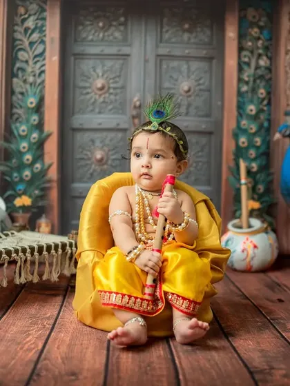 A thoughtful portrait of baby Krishna, looking slightly off-camera.