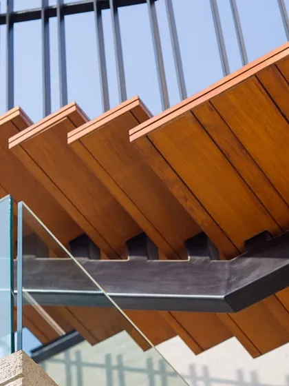 Craftsmanship is in the details. This close-up of a staircase shows the careful joinery of wood and metal, a testament to our belief that even functional elements should be beautifully executed.