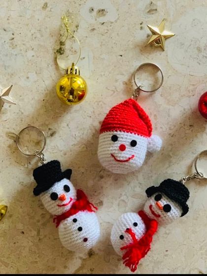 My snowman and Santa head keychains are a cute and festive accessory for the holiday season, shown here with other Christmas trinkets.