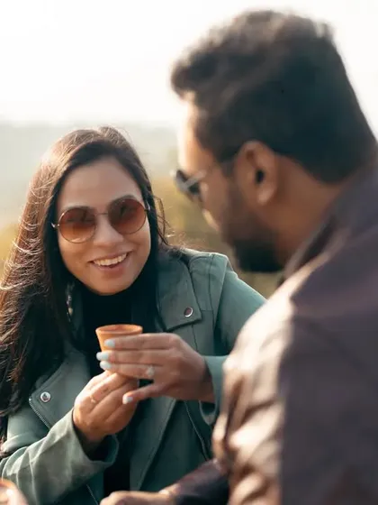 A beautiful, candid shot of the couple enjoying their chai. Her genuine smile as she looks at him speaks volumes about their easy, happy connection.