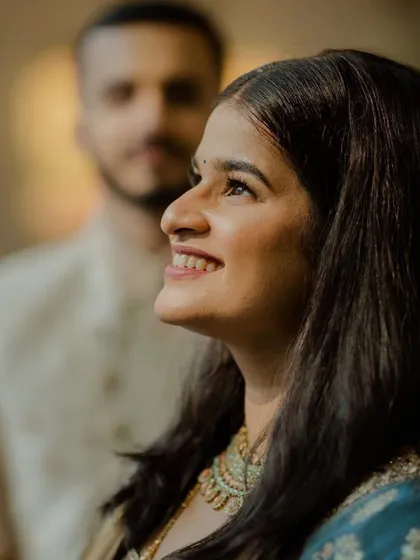 A happy bride with her groom. The makeup is fresh and radiant, capturing the joy of the moment perfectly.
