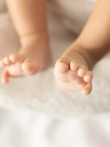 A close-up on a newborn's feet, showing every perfect little wrinkle and toe. These are the details that make your heart melt.