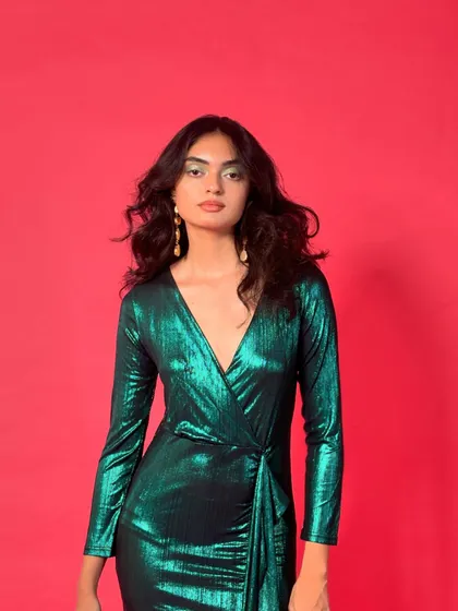This portrait captures the confident attitude of the "Gliterati Chica" look, with voluminous hair and striking makeup complementing the vibrant dress.
