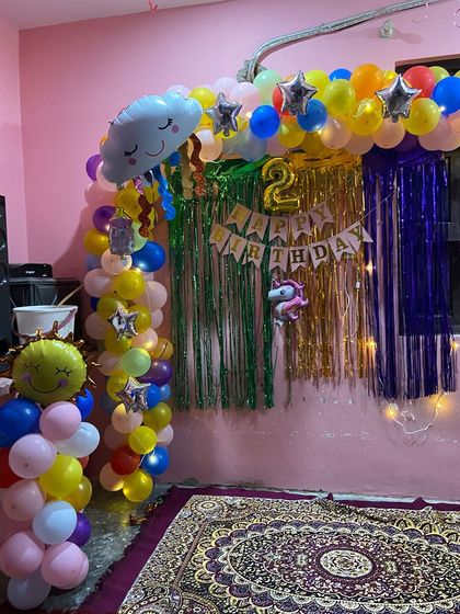 Another view of the rainbow birthday backdrop, showing the mix of colorful balloons, star foils, and character balloons like a unicorn.