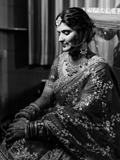 I love using black and white to create dramatic and timeless portraits. This image of a North Indian bride captures a moment of quiet reflection, with the monochrome tones emphasizing the rich embroidery of her lehenga.