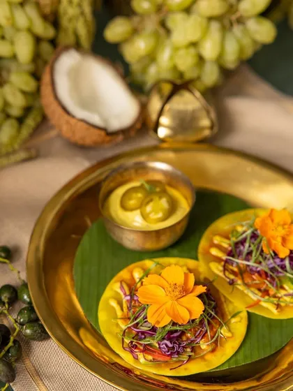 Colorful mini tacos garnished with edible flowers, served with a side of creamy dip, a playful and delicious part of our festive offerings.