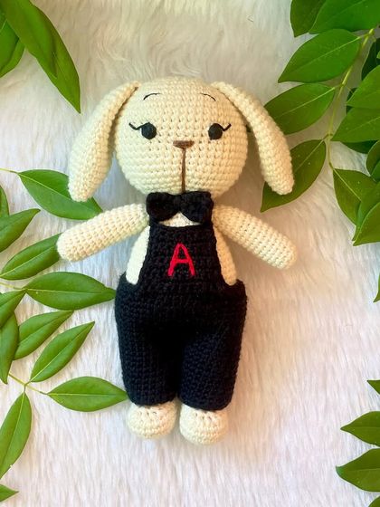 A dapper boy bunny! This little buck looks so smart in his black overalls with a personalized initial and a matching bow tie.