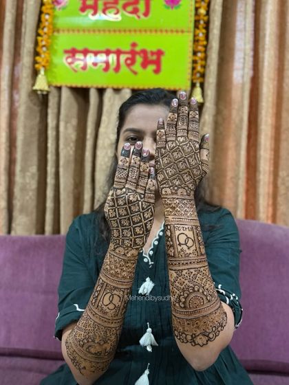 A full view of Shreya's engagement mehendi, which includes symbolic rings and initials.