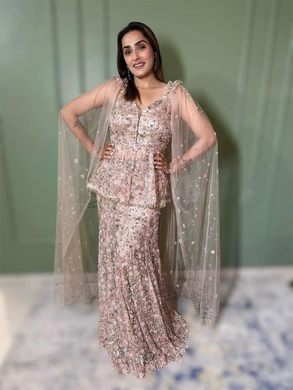 This peplum-style gown with a cape is a unique and modern choice for a reception or engagement. The intricate beadwork is simply stunning.