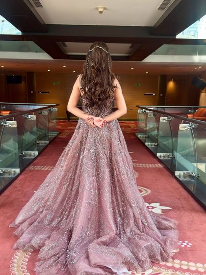 The full effect of the princess hairstyle from the back. The long, voluminous curls cascade beautifully over the shimmery gown, creating a true fairytale moment.