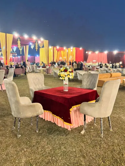 Another perspective of the outdoor seating, showing the vastness of the lawn and the impressive scale of the main tent structure in the background.