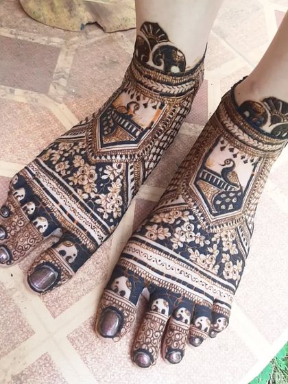 This design features peacocks in frames on the top of the feet, with small elephants marching around the toes and ankles.