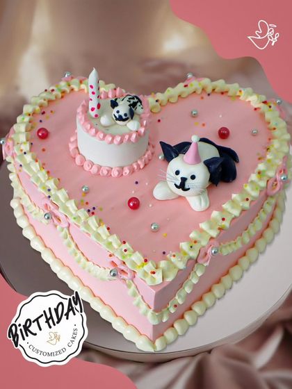 A sweet heart-shaped cake with cute fondant cats. This charming and unique design is perfect for a cat lover's birthday.