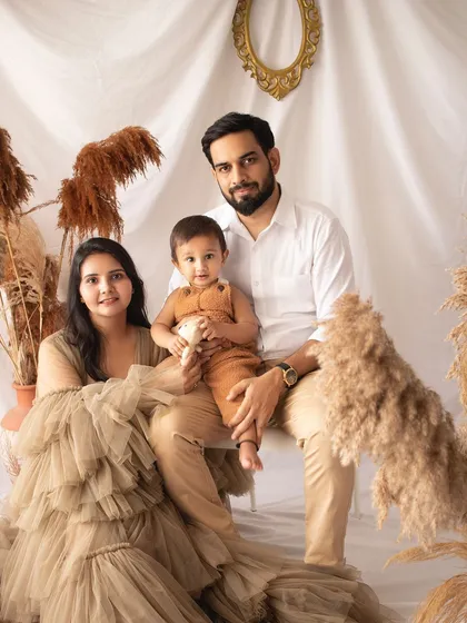 A formal family portrait with a boho twist. The mother's beautiful gown and the earthy tones of the set create a unique and stylish look.