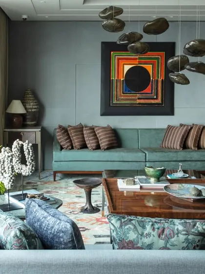 A living room space from 'The 42, Kolkata' as featured in Elle Decor. The room balances bold art, like the S.H. Raza piece, with comfortable, custom-made furniture and layered textures.