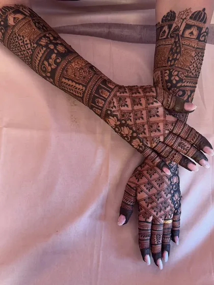 The back of the hands for the Shiva-Parvati and Radha-Krishna bridal design. The intricate jaal (net) pattern is flawlessly executed, covering the hands in a delicate web of henna.