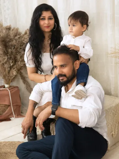 A stylish family portrait in the studio, with a little boy sitting on his father's shoulders, creating a strong and connected pose.