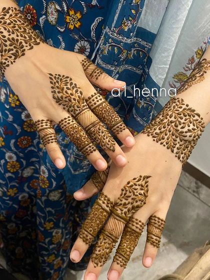 This design features leafy cuffs on the wrists and detailed finger work, offering a modern and chic alternative to full-hand henna.