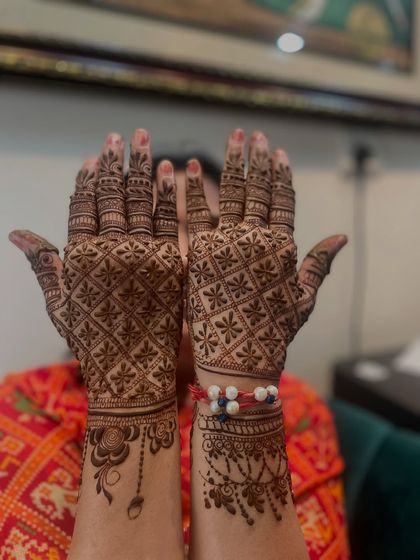 The full view of the Rakhi mehandi. The client is happily showing off both her hands.