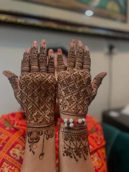 The full view of the Rakhi mehandi. The client is happily showing off both her hands.