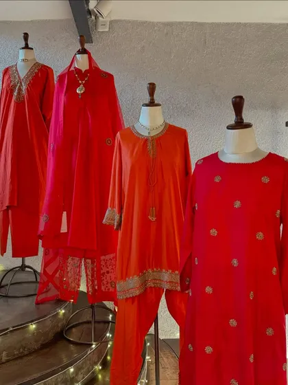 A wider view of the red collection by Brih, showcasing the luxurious silk fabric and the fine hand-embroidery that defines the brand.
