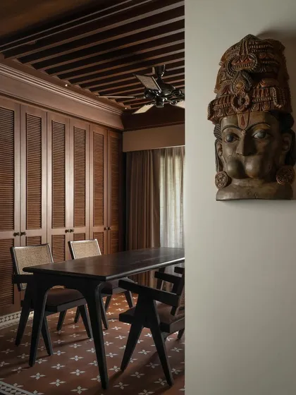 A carved wooden Hanuman mask adorns the wall, a powerful cultural artifact that adds another layer to the home's narrative.